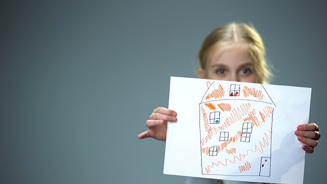 Kid showing house picture into camera, poor family needing home, social support